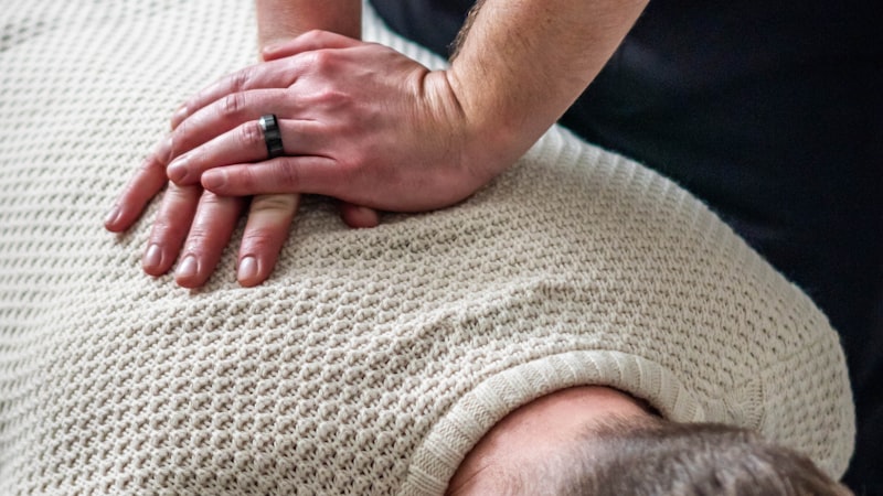 A chiropractor adjusting a patient's upper back and neck